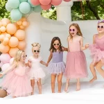 Children joyfully bouncing in a colorful inflatable bounce house at a backyard party.