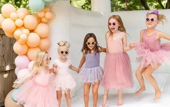 Children joyfully bouncing in a colorful inflatable bounce house at a backyard party.